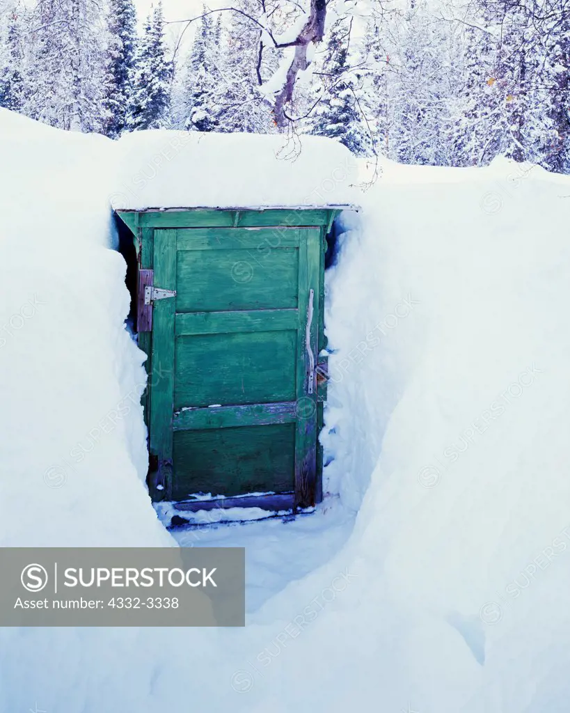 USA, Alaska, Outhouse at Winterlake Lodge buried in deep winter snow