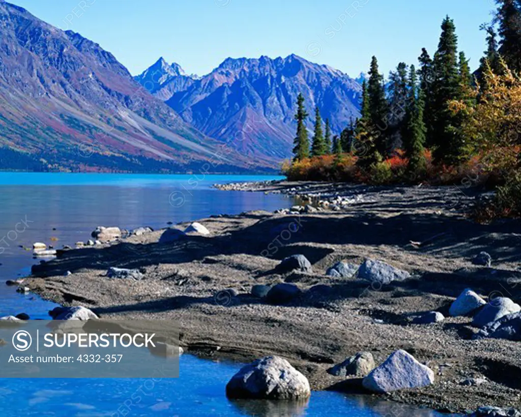 Glacial erratics are rocks, from small to boulder sized, that are deposited by retreating glaciers. Autumn view of Upper Twin Lake shore on Hope Creek's Delta, Lake Clark National Park, Alaska.