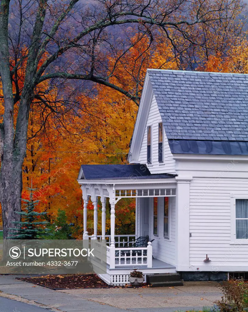 USA, Vermont, Rochester, Front porch of New UK, England home with autumn colors of sugar maples