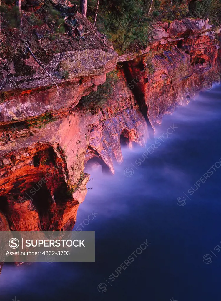 USA, Wisconsin, Apostle Islands National Lakeshore, Eerie light of dusk illuminating Squaw Bay Caves carved in billion-year-old Devil's Island Formation sandstone on Lake Superior