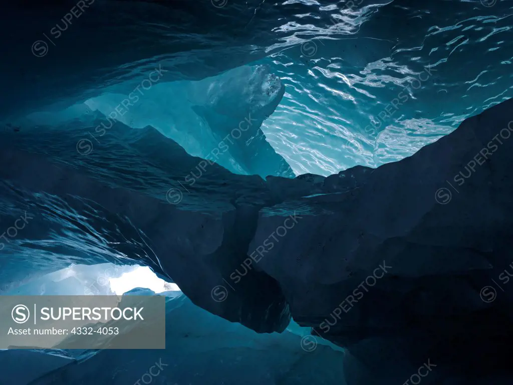 Large sculpted fin in ice cave within 'Moulin Glacier' with ice boulders on floor from earlier ceiling collapse, Chugach Mountains, Alaska.