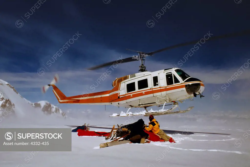 A Bell 205 Helicopter departing the summit crater of Redoubt Volcano, after dropping off a research team from the Alaska Geophysical Institute and Lake Clark National Park, Alaska.