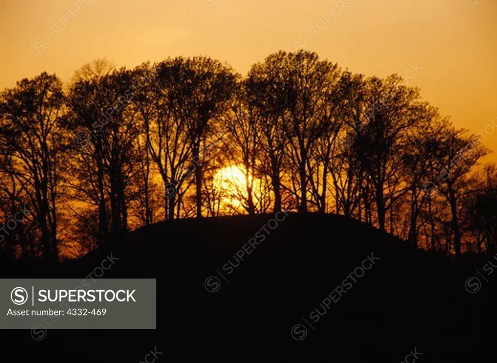Sun setting beyond earthwork mound built by people of the Plum Bayou Culture, Lower Mississippi Valley, Toltec Mounds Archeological State Park, Arkansas.