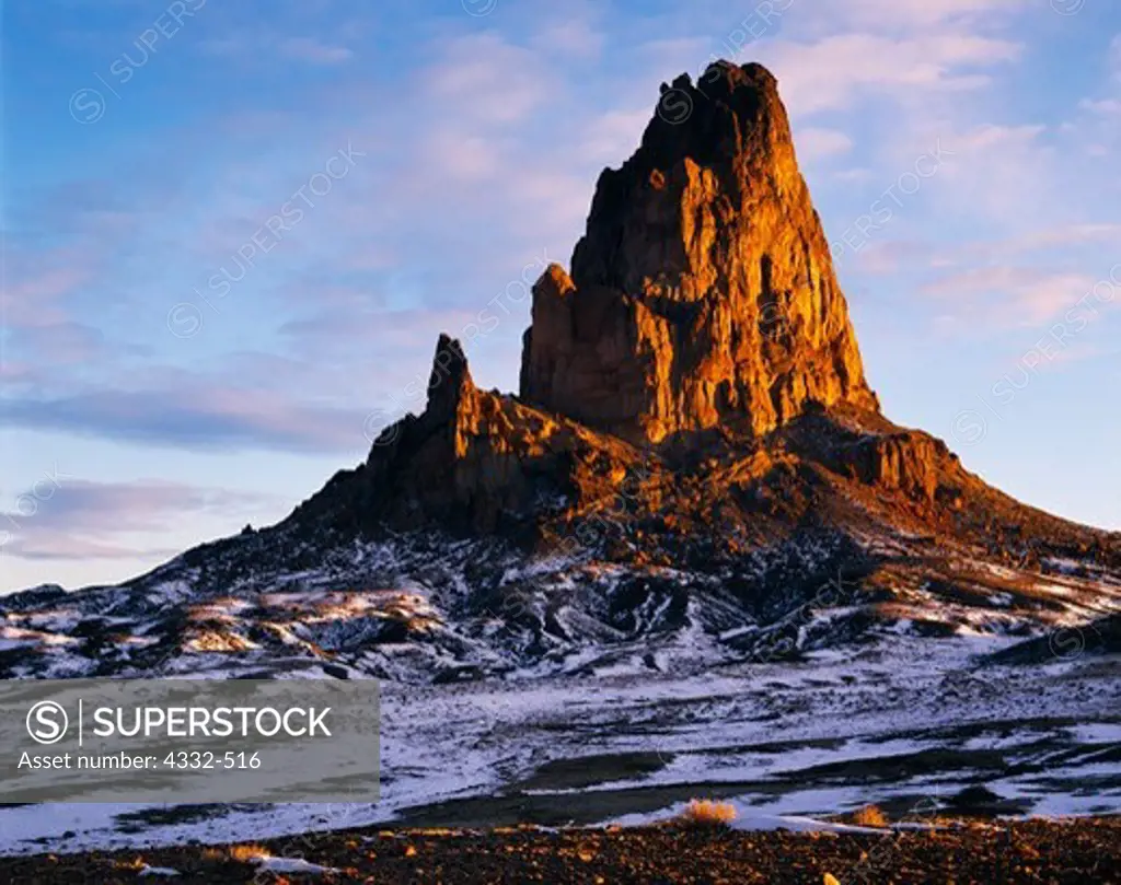 Warm light of winter sunrise stricking the volcanic neck of 7,100 foot Agathla Peak, Navajo Reservation, Arizona.