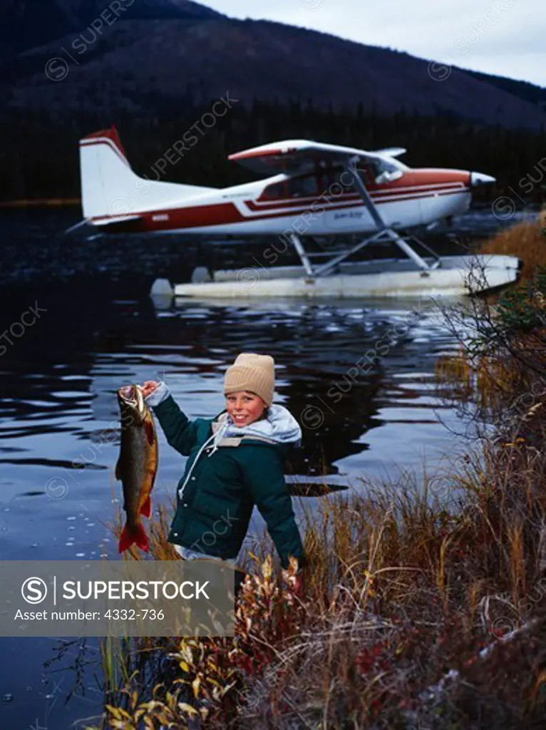 Bush pilot's son, Tyler Klaes, proudly displays a Lake Trout in spawning colors just caught in a small lake near the Alatna River on the south side of the Brooks Range, Alaska.