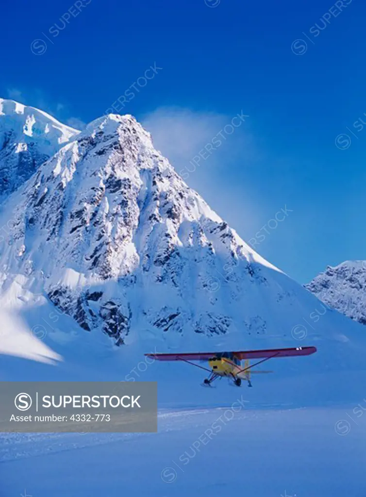 Pilot George Murphy with his Aeronca 15AC Sedan on wheel skis taking off from the Ruth Glacier on the south side of the Don Sheldon Amphitheater, Denali National Park, Alaska.