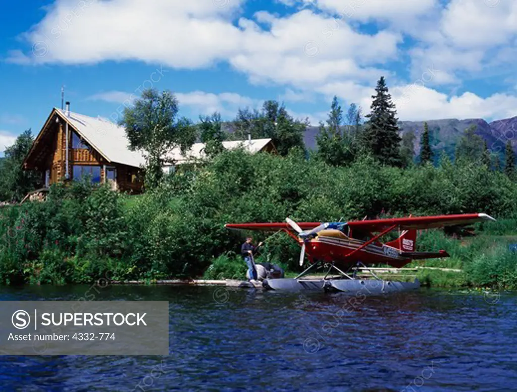 Carl Dixon helping launch Rust's Flying Service's Cessna 206 from dock at Winterlake Lodge, Finger Lake, Alaska.