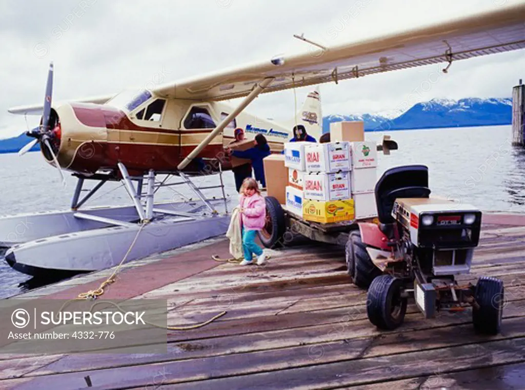 Pegues family unloading groceries for Snyder Mercantile from Mike Mill's Beaver, dock at Tenakee Springs, Chichagof Island, Southeast Alaska.