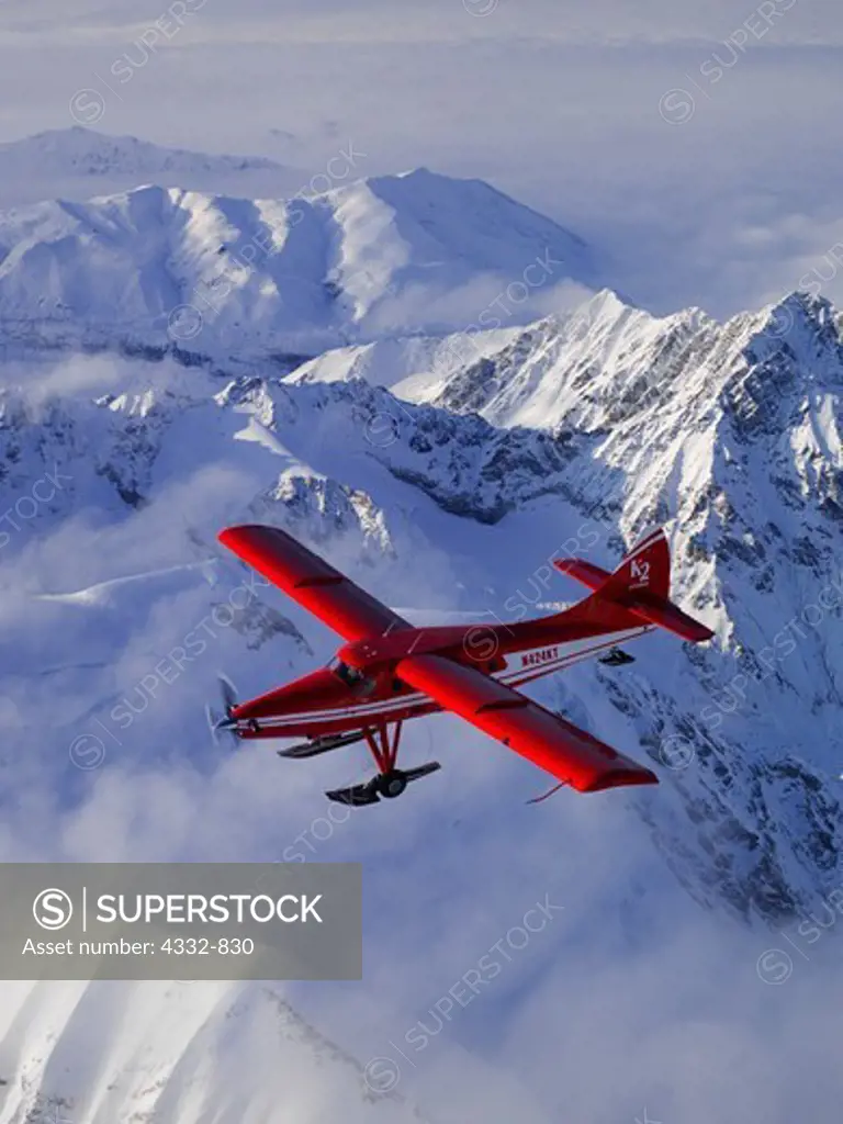 K2 Aviation's Turbo Otter on wheel skis flying above the Alaska Range in Denali National Park, Alaska.