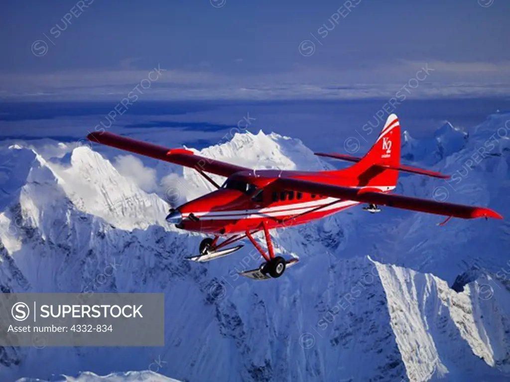 K2 Aviation's Turbo Otter on wheel skis flying above the Alaska Range in Denali National Park, Alaska.