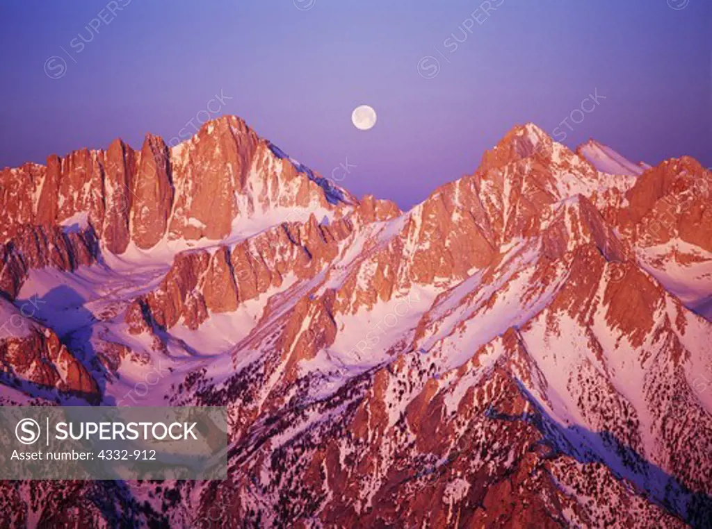 Aerial view of full moon setting between Mount Russell and 14,495 foot Mount Whitney, sunrise over Inyo National Forest with Sequoia National Park beyond, California.