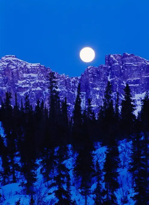 Full moon rising above rugged face of the Philip Smith Mountains east of the Dietrich River, Brooks Range, Alaska.