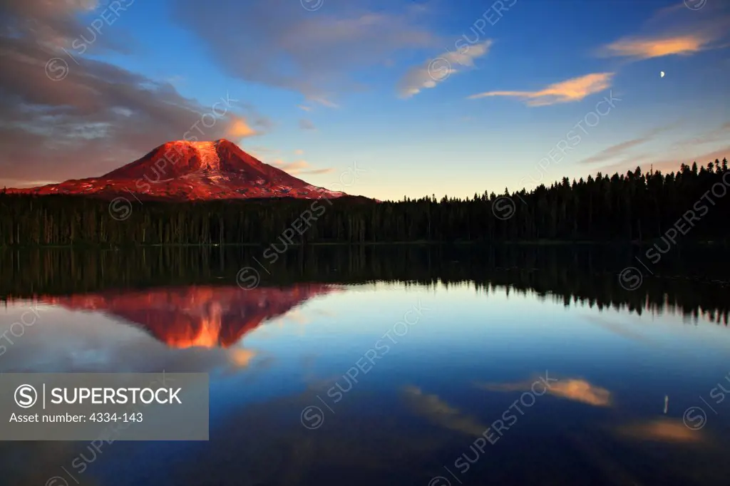 Sunset reddens Mount Adams, a smaller Cascades volcano east of Mount Saint Helens, which is reflected in nearby Takhlakh Lake, Gifford Pinchot National Forest, Washington.