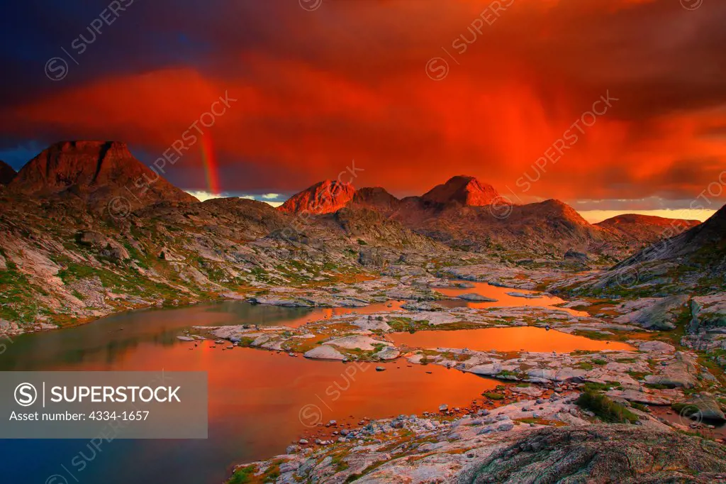 USA, Wyoming, Amazing sunset on storm clouds with vertical rainbow over Lower Titcomb Lakes Basin in Bridger Wilderness of Bridger-Teton National Forest in Wind Rivers Range