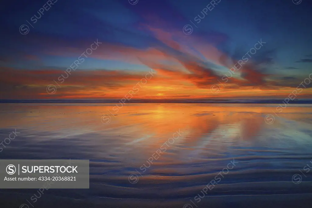 Sunset Colors Over the Pacific Ocean Reflected In The Sand From Cannon Beach in Oregon
