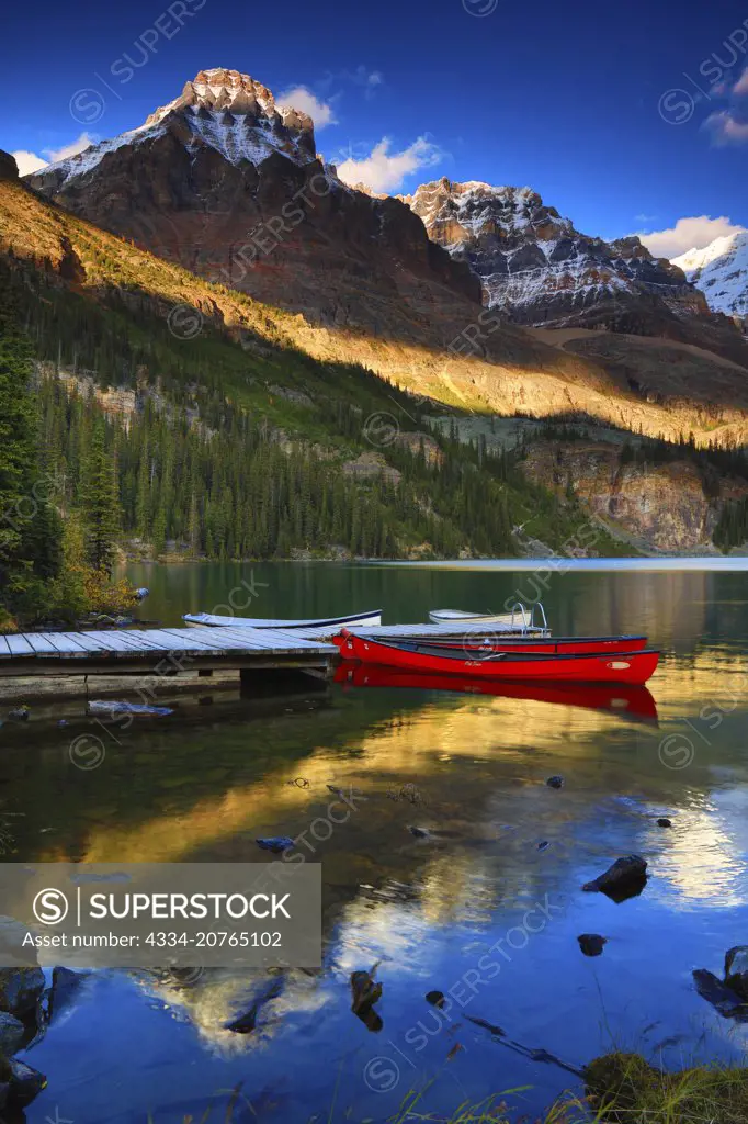 Evening Light With Dock and Canoes on Lake O'Hara With Wiwaxy Peaks in the Canadian Rockies of Yoho National Park in British Columbia Canada