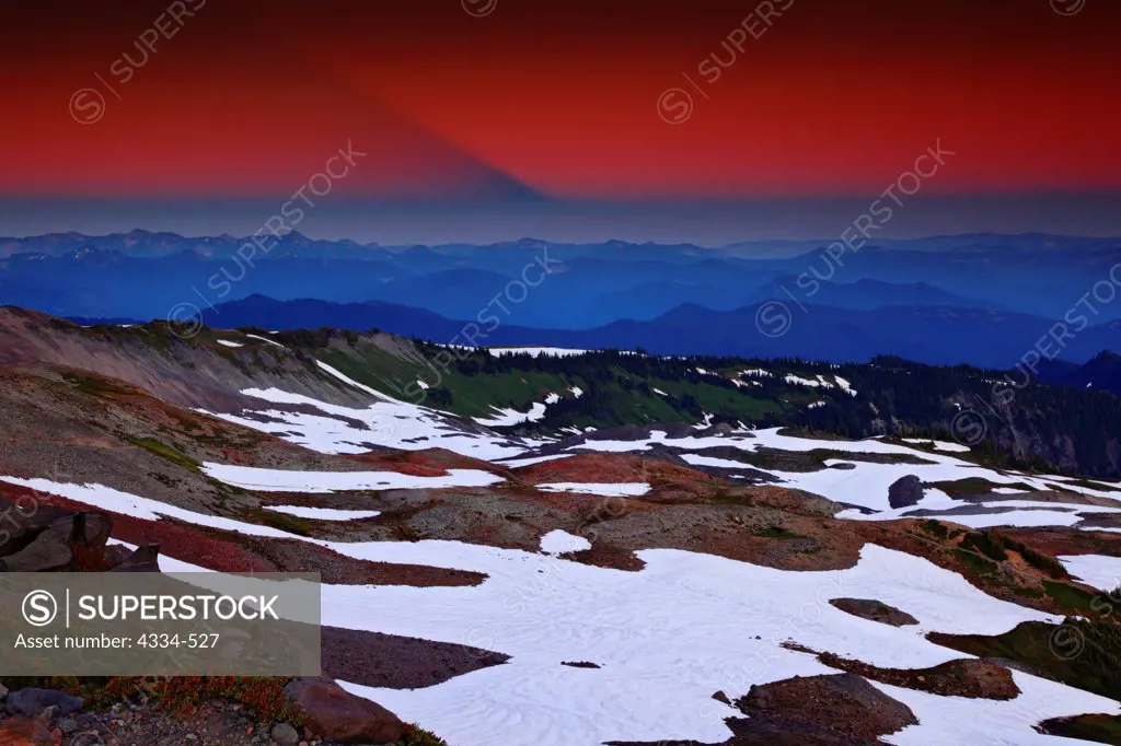 Mount Rainier casts a shadow at sunset, viewed from Panorama Point in Mount Rainier National Park, Washington.