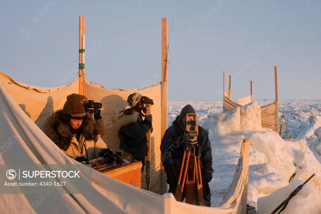 Scientists conducting a bowhead whale (Balaena mysticetus) survey standing in an observation area in rough pack ice to count passing migrating whales during their spring migration, on the Chukchi Sea, off shore from Barrow, Alaska.  The survey is conducted every 5 years.