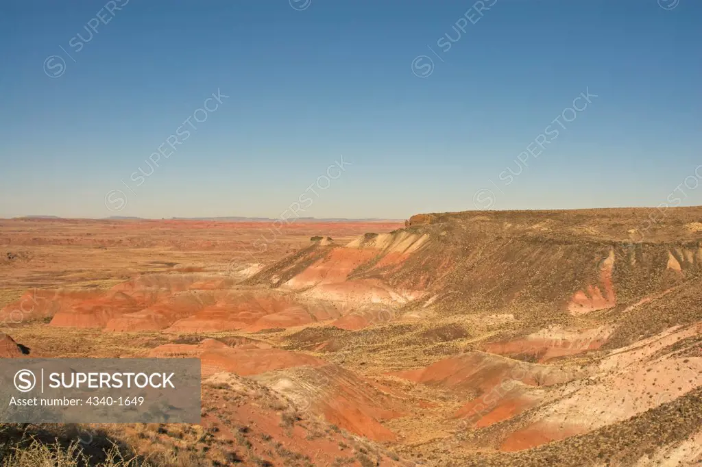 The multi-hued badlands of the Painted Desert include sandstone and clay, dark layers reflect high carbon content, and the reds are iron-stained siltstone, in Petrified Forest National Park, Arizona.