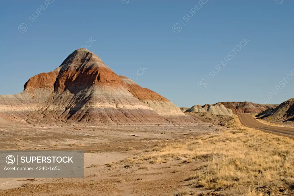The multi-hued badlands of the Painted Desert include sandstone and clay, dark layers reflect high carbon content, and the reds are iron-stained siltstone. These hills in the Petrified Forest National Park are called The Teepees.