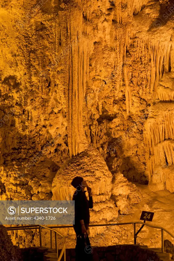 A tourist observes the massive underground formations in the wondrous 8.2-acre Big Room cave, 750 feet into the earth, Carlsbad Caverns National Park, Chihuahuan Desert, New Mexico.