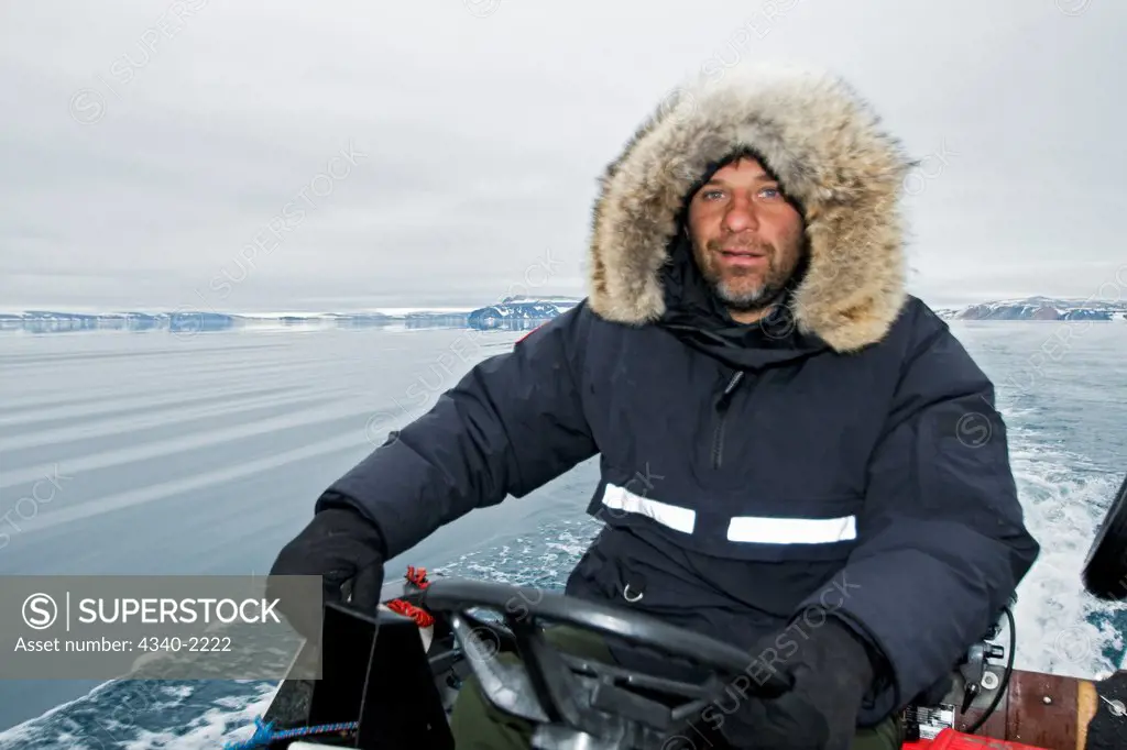 Photographer Steven Kazlowski drives a zodiac in search for polar bears during an expedition to photograph wildlife in Svalbard, Norway.