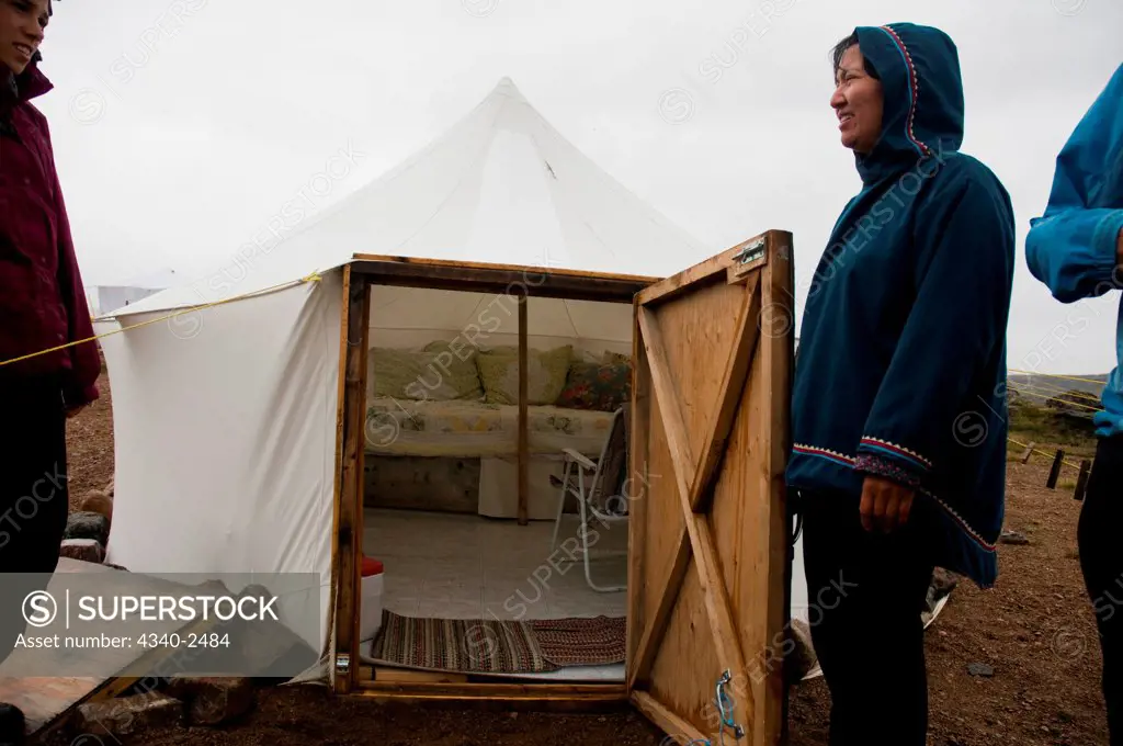 Inuit woman outside tent at base camp along the Sylvia Grinnell River, Sylvia Grinnell Territorial Park, outside the capital city of Iqaluit, Baffin Island, Nunavut Territory, Canada