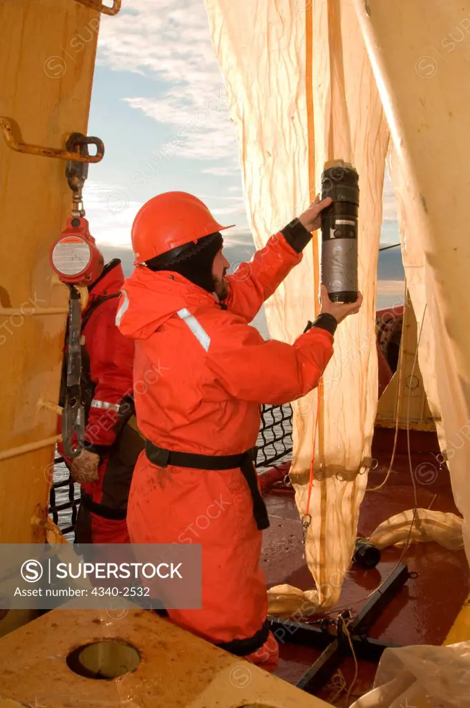 ArcticNet scientist collects sample of juvenile fish using a Rectangular Mid-Water Trawl deployed from the foredeck of the CGGS Amundsen, Baffin Bay, Nunavut, Canada