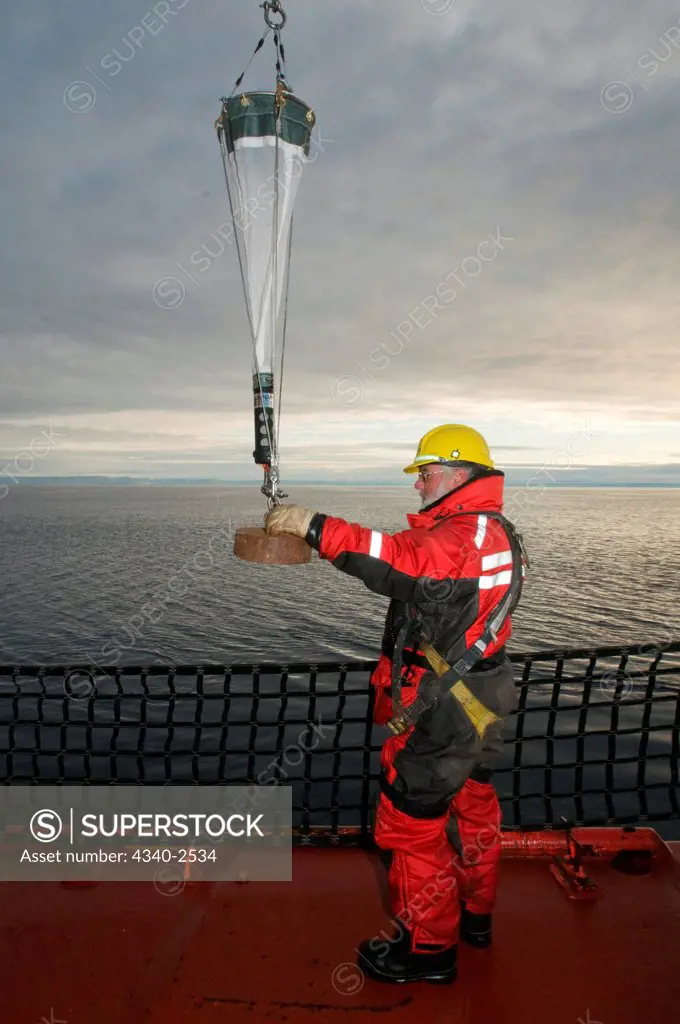 ArcticNet scientist deploys a bongo net, another fine mesh zooplankton tow net, used to pull up and study benthic organisms, aboard the CCGS Amundsen, Northwest Passage, Nunavut Territory, Canada