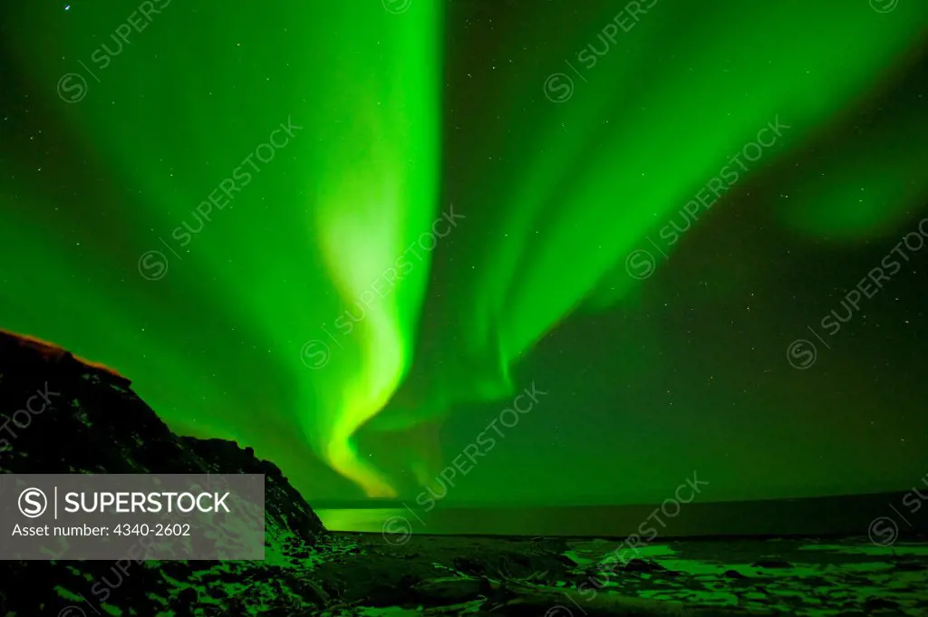 Northern lights, Aurora borealis, glow brightly and snake across the autumn night sky, over the Beaufort Sea and off shore from the 1002 area of the Arctic National Wildlife Refuge, North Slope of the Brooks Range, Alaska