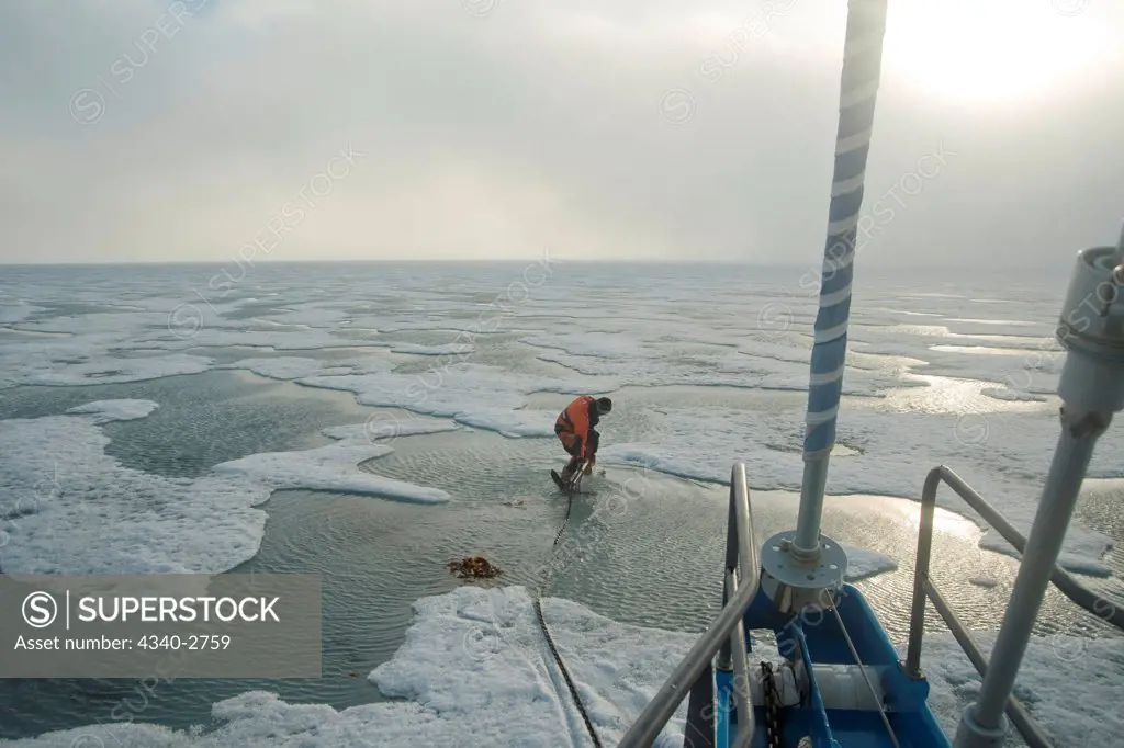 Sailboat captain drops anchor in fjord ice along the northwest coast of Spitsbergen, Svalbard Archipelago, Norway, Summer