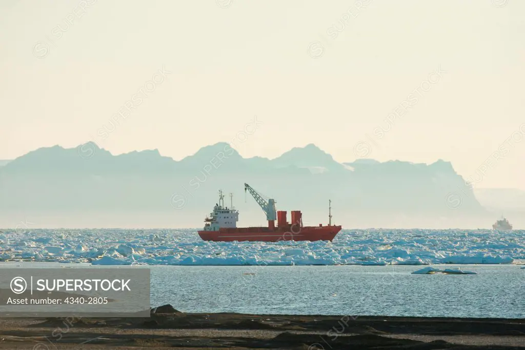 cargo ship sits amidst unusual sea ice amassed outside Longyearbyen, before it breaks ice for a caravan of ships, located in Isfjorden, western Spitsbergen, Svalbard Archipelago, Norway
