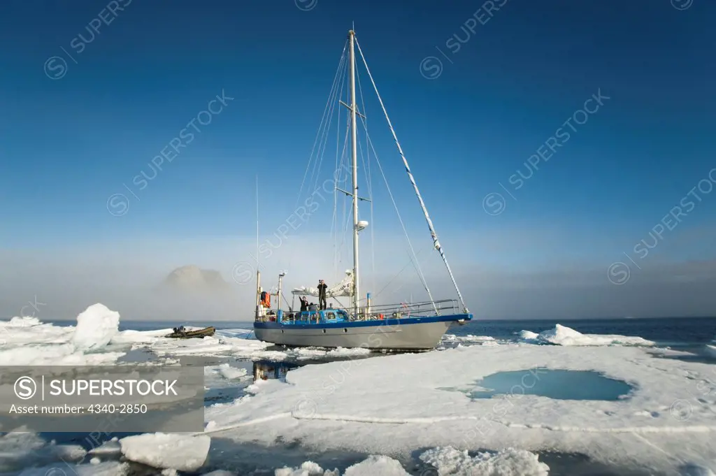 Norway, Svalbard Archipelago, Arctic Ocean, Expedition sailing yacht amongst sea ice with ice rainbow in distance