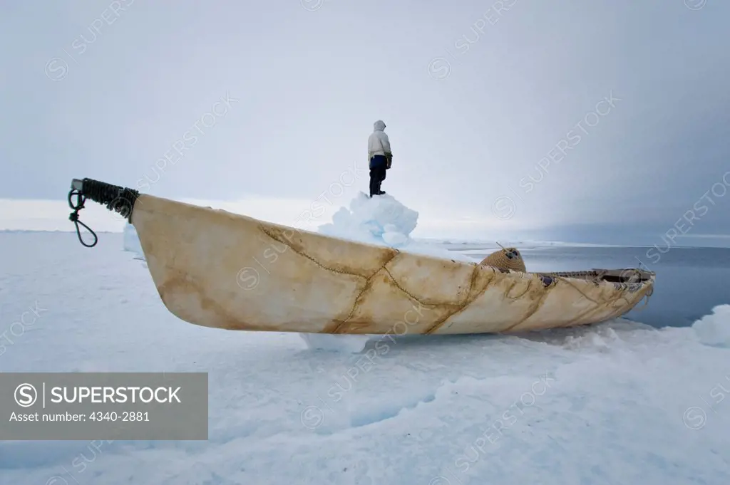 USA, Alaska, Inupiaq whaler with an umiak standing on jumbled ice at edge of open lead