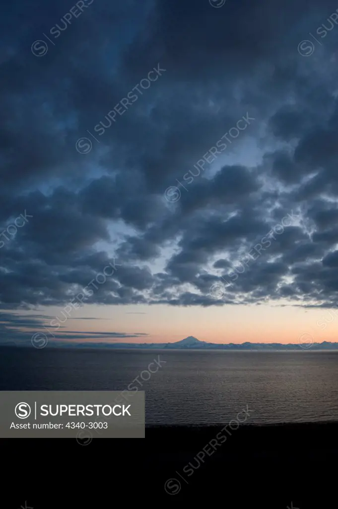 USA, Alaska, Kenai Peninsula, Kasilof, across Cook Inlet, View of Mount Redoubt, active volcano, along Aleutian range, at sunset, spring