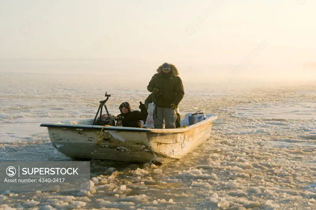 Photographers in a skiff along the coast during fall freeze up, Arctic National Wildlife Refuge, North Slope, Alaska, USA