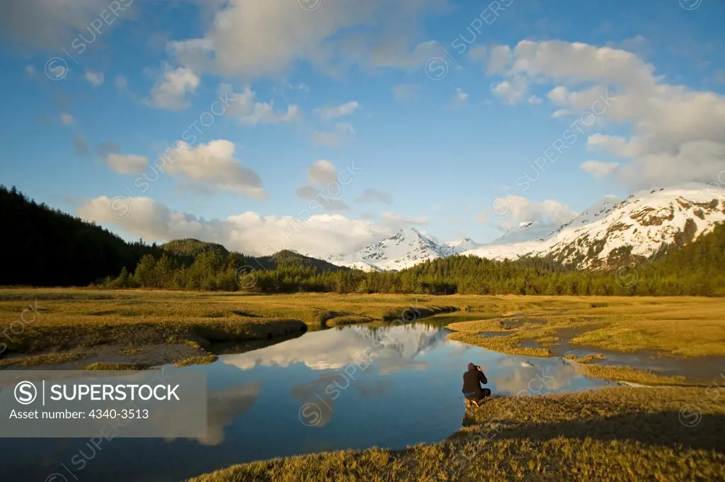 Photographer taking picture of a river with a mountain range in the background, Copper River, Wrangell Mountains, Cordova, Alaska, USA