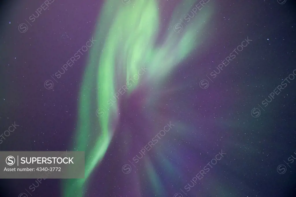 USA, Alaska, Beaufort Sea, Northern lights (Aurora borealis) glowing brightly over Inupiaq fish camp along arctic coast
