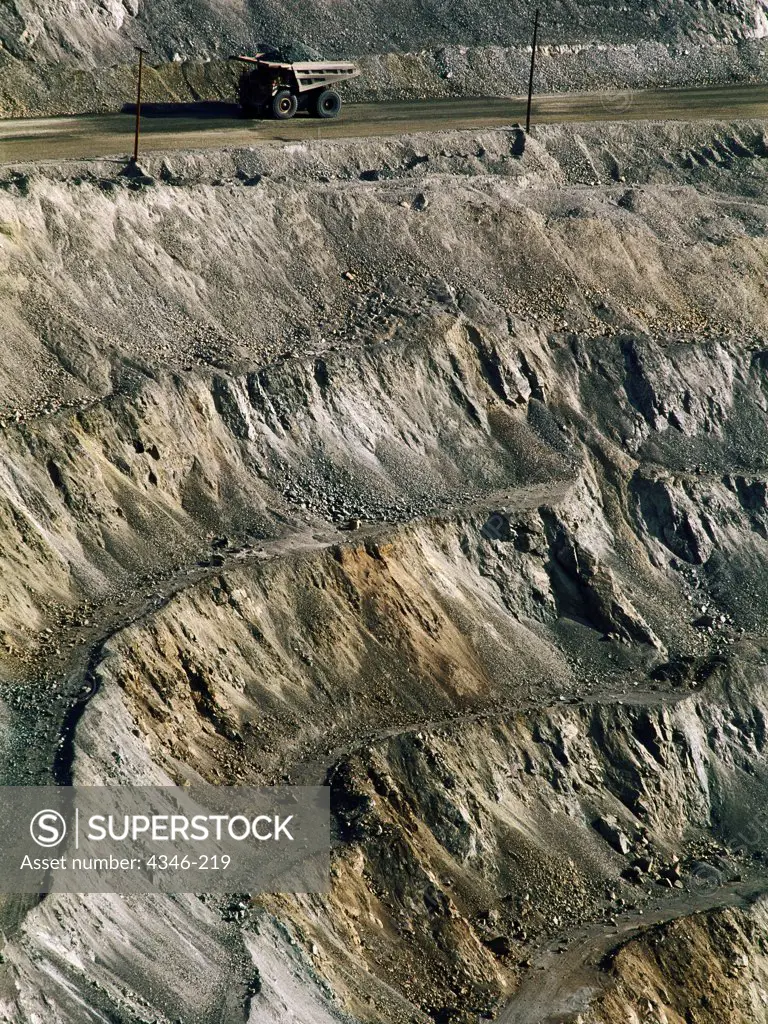 An Enormous Mining Truck Is Dwarfed by an Open Pit Mine