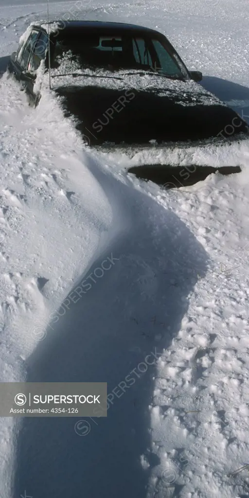 An Abandoned Car Buried Deep in Drifting Snow