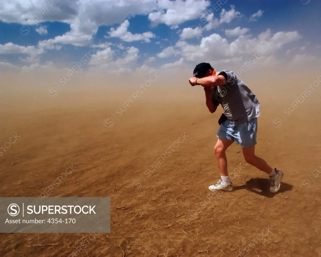 A Man Struggles Against a Dust Storm as It Roars Across a Drought-Stricken Field