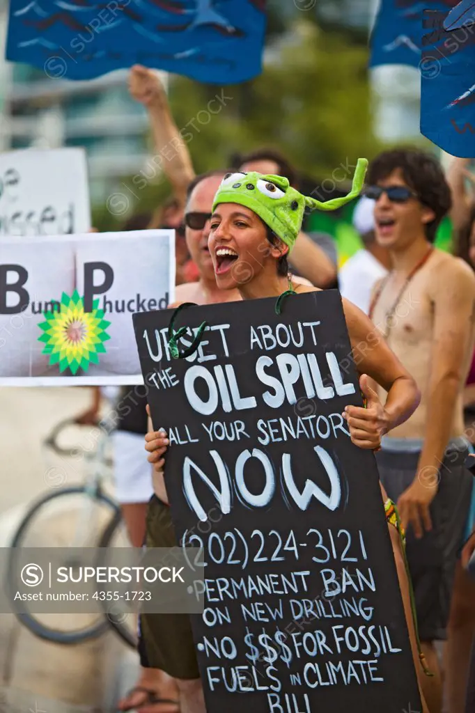 Participants in the Miami Naked Bicycle Race hold signs urging action on the Gulf of Mexico oil spill.
