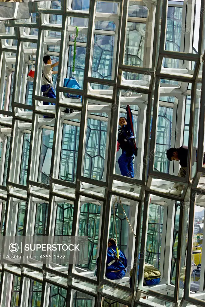 Workers in the honeycomb cladding of the Icelandic National Concert and Conference Center.