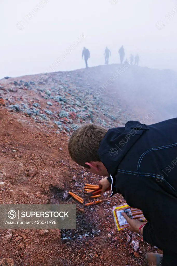 Cooking hotdogs on the ground at the summit of The Eyjafjallajokull Volcano in Iceland one year after the eruption. Lava just under the surface is still around 700 degrees. Lava broke through the Gigjokull Glacier causing violent eruptions and large amounts of ash that caused worldwide aviation nightmares shutting down almost all of Europe for days in 2010.
