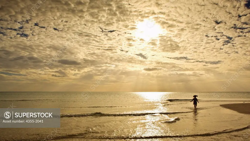 Little girl splashing in the warm gulf waters in Naples, Florida.