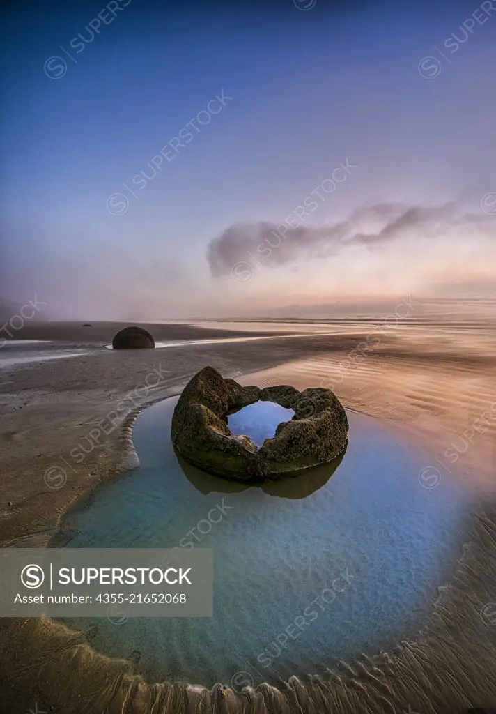 The Moeraki Boulders are large spherical boulders lying along a stretch of Koekohe Beach on the Otago coast of the South Island in New Zealand