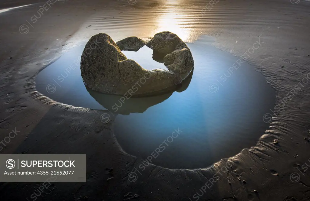 The Moeraki Boulders are large spherical boulders lying along a stretch of Koekohe Beach on the Otago coast of the South Island in New Zealand