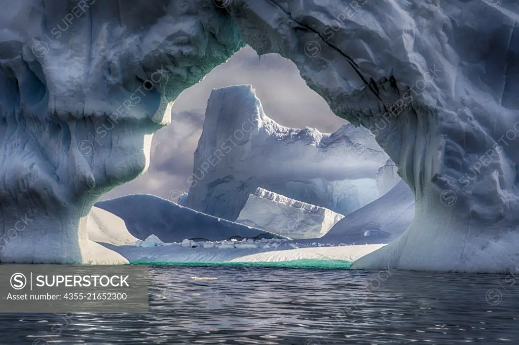 An iceberg with a large arch near Vernadsky Station in Antarctica