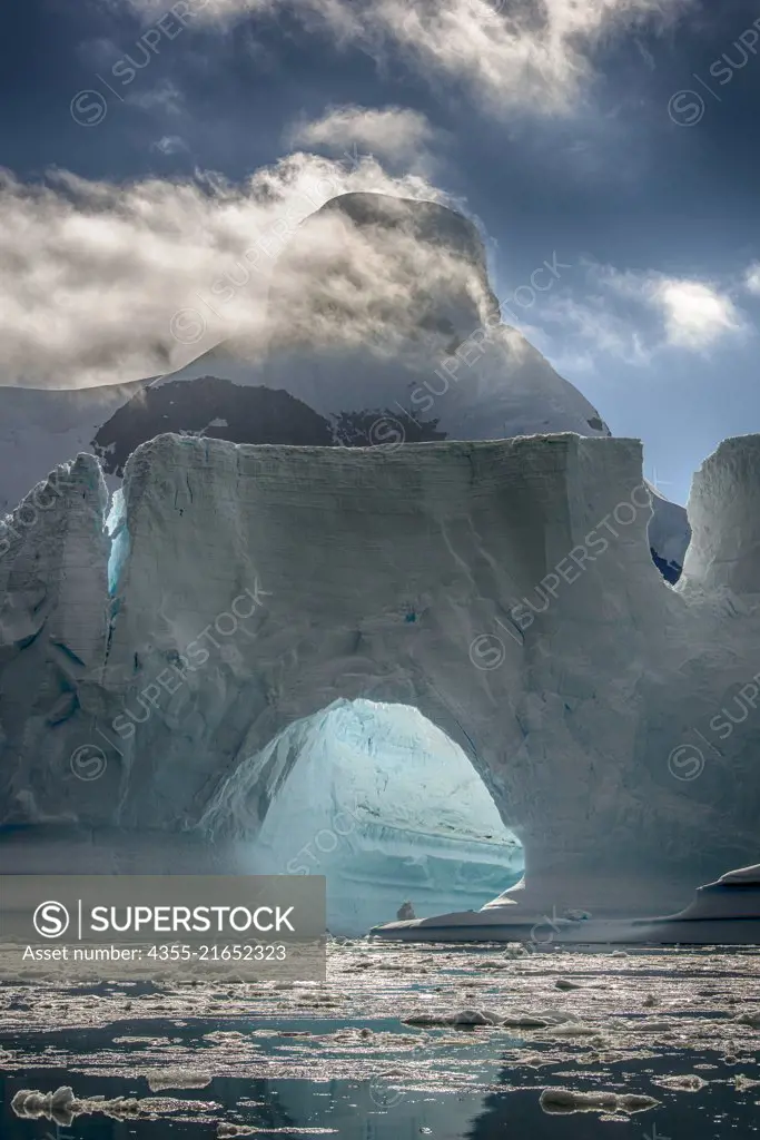 A mammoth tabular iceberg with an arch in the Yalour Islands, a group of islands and rocks in the south part of the Wilhelm Archipelago, of Antarctica.
