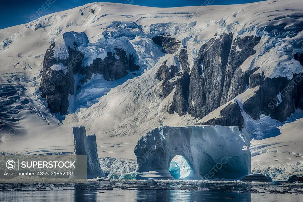 A mammoth tabular iceberg with an arch in the Yalour Islands, a group of islands and rocks in the south part of the Wilhelm Archipelago, of Antarctica.
